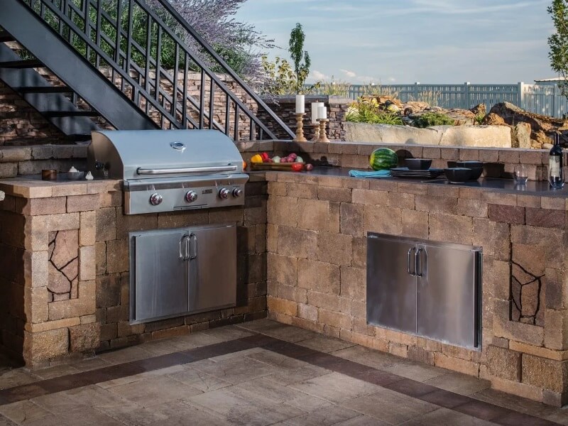 Outdoor kitchen and firepit with paver patio in Los Angeles